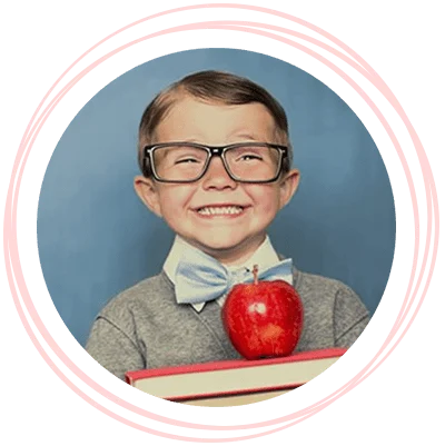 Happy child with glasses holding books and an apple on top